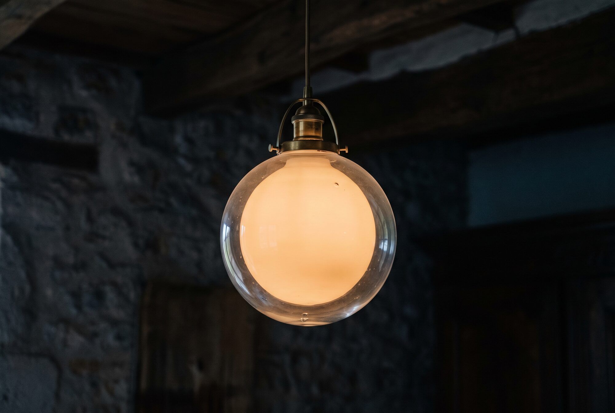 Photo d’une suspension en laiton et verre soufflé, allumée